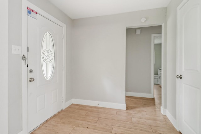 foyer entrance featuring baseboards and wood tiled floor