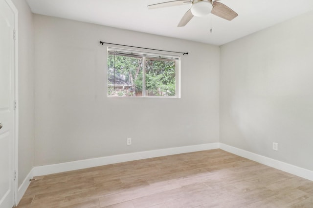 empty room with a ceiling fan, light wood-style flooring, and baseboards