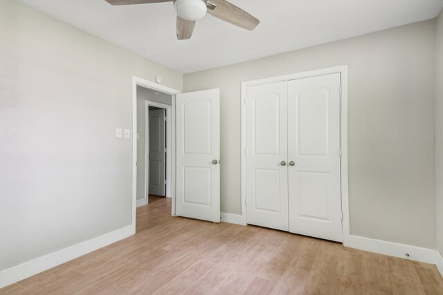 unfurnished bedroom featuring ceiling fan, light wood-type flooring, and a closet