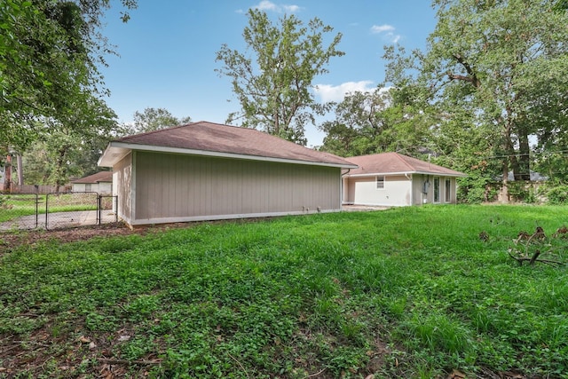 view of side of home featuring fence and a lawn