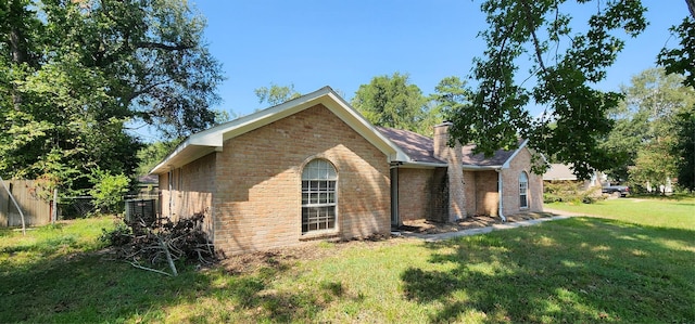 view of property exterior featuring a yard, brick siding, fence, and a chimney