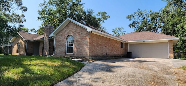 ranch-style house with an attached garage, brick siding, concrete driveway, a chimney, and a front yard