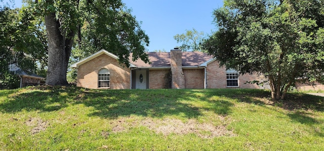 single story home with a chimney, a front lawn, and brick siding