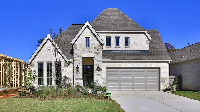 17727 Monarch Vista Ln, Conroe, TX 77302 - view of front facade with a shingled roof, concrete driveway, stone siding, and an attached garage