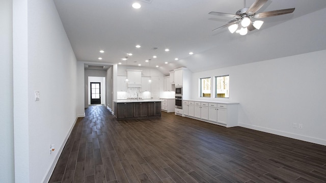 unfurnished living room with vaulted ceiling, ceiling fan, and dark wood-type flooring