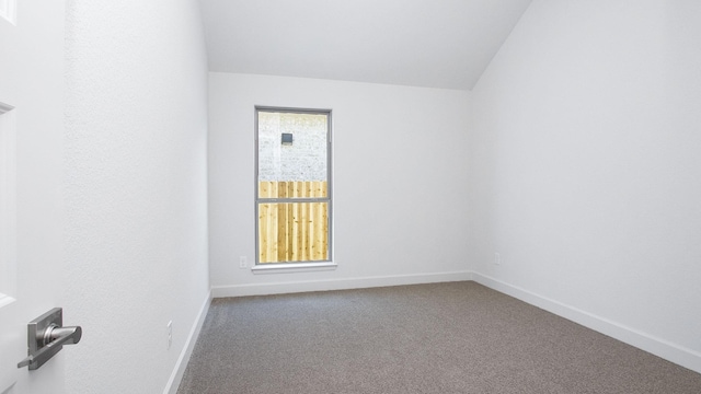 carpeted spare room featuring lofted ceiling