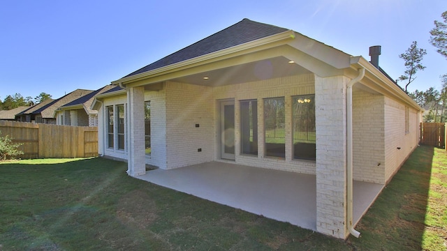 rear view of property featuring a patio and a lawn