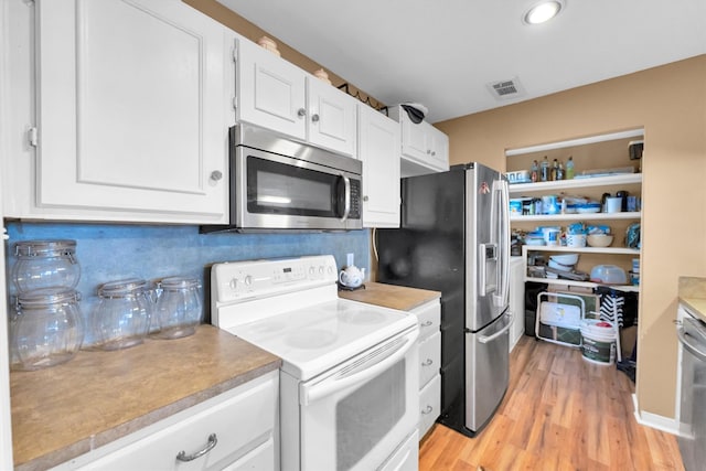 kitchen with appliances with stainless steel finishes, light wood-type flooring, white cabinetry, and decorative backsplash