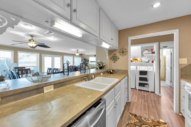 kitchen with white cabinets, light hardwood / wood-style flooring, ceiling fan, sink, and washer and dryer