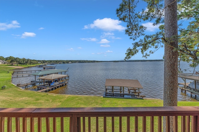 dock area with a lawn and a water view