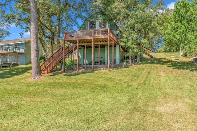 rear view of property featuring a lawn and a wooden deck