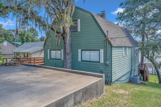 view of property exterior featuring cooling unit and a yard