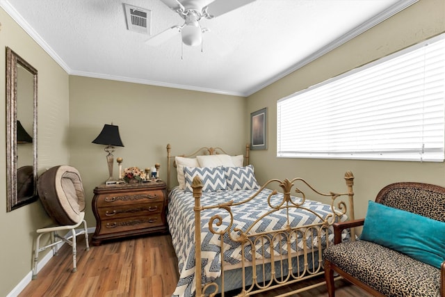 bedroom with ceiling fan, crown molding, and wood-type flooring