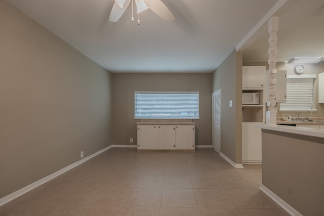 interior space with sink, ceiling fan, and light tile patterned flooring