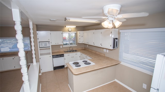 kitchen featuring white appliances, kitchen peninsula, sink, and white cabinets