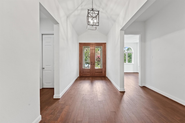 entryway featuring a chandelier, dark wood-type flooring, lofted ceiling, and baseboards