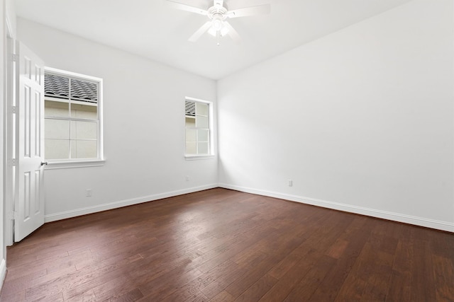 empty room with a ceiling fan, dark wood-style flooring, a healthy amount of sunlight, and baseboards