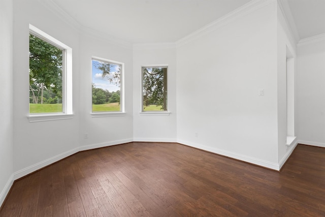 spare room with ornamental molding, dark wood finished floors, and baseboards