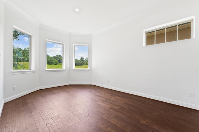 empty room featuring dark wood-style flooring, crown molding, and baseboards