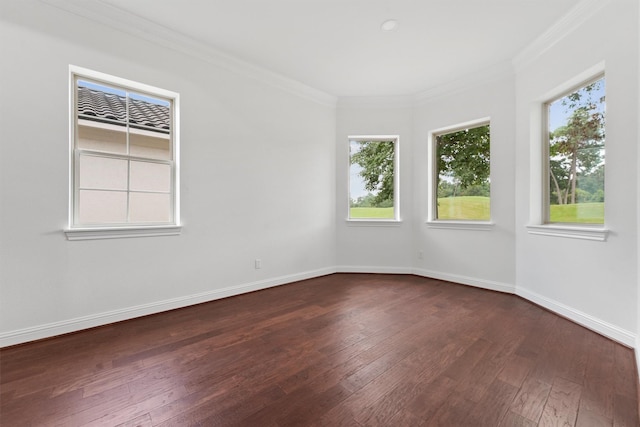 unfurnished room with ornamental molding, dark wood-style flooring, and baseboards