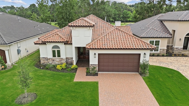 mediterranean / spanish-style house featuring a garage and a front yard