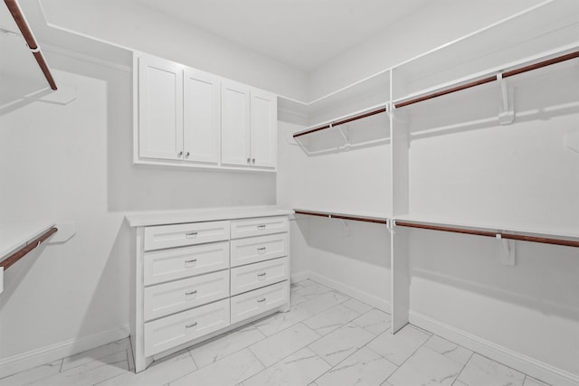 walk in closet with marble finish floor