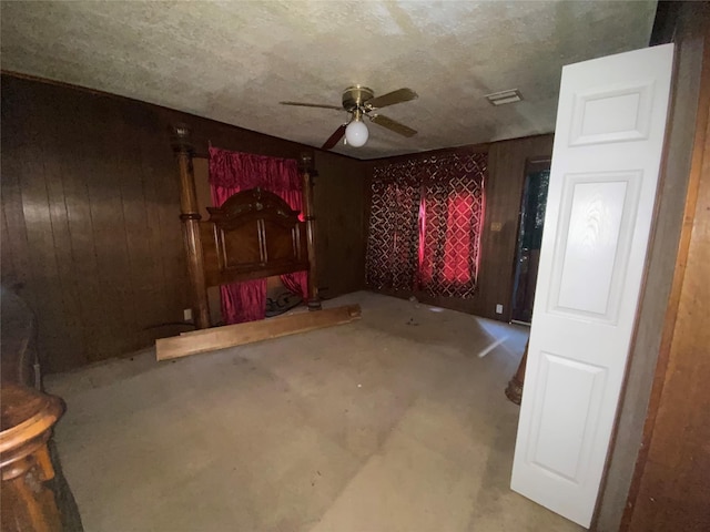 interior space with wooden walls and ceiling fan