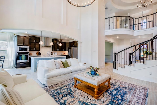 living room with sink, a towering ceiling, and an inviting chandelier