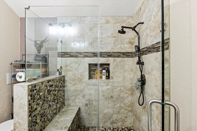 bathroom featuring toilet, a shower with door, and a textured ceiling