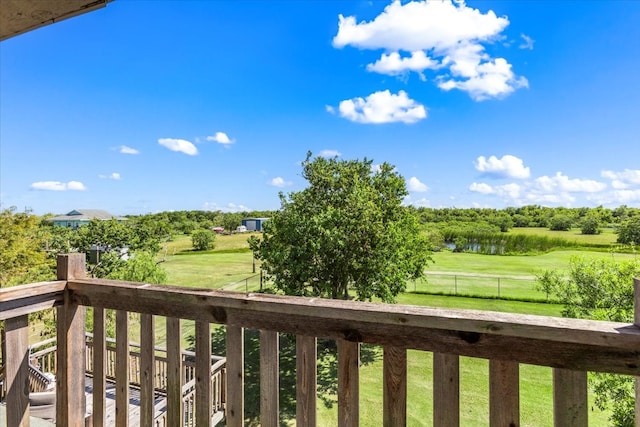 wooden deck with a water view and a lawn