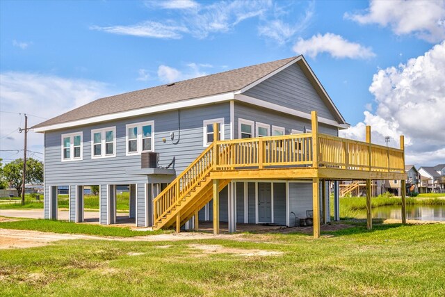 rear view of house featuring a wooden deck and a lawn