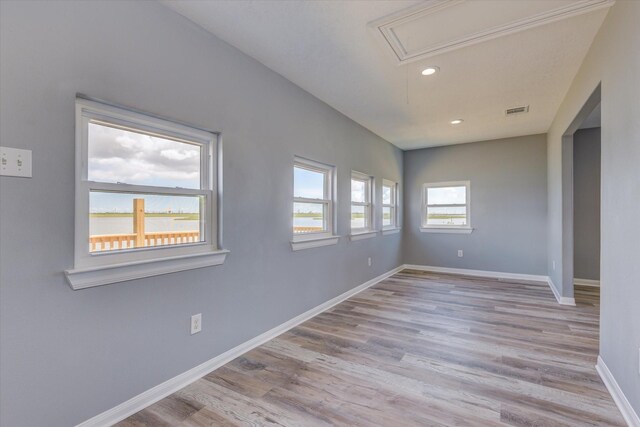 spare room with wood finished floors, visible vents, baseboards, attic access, and recessed lighting