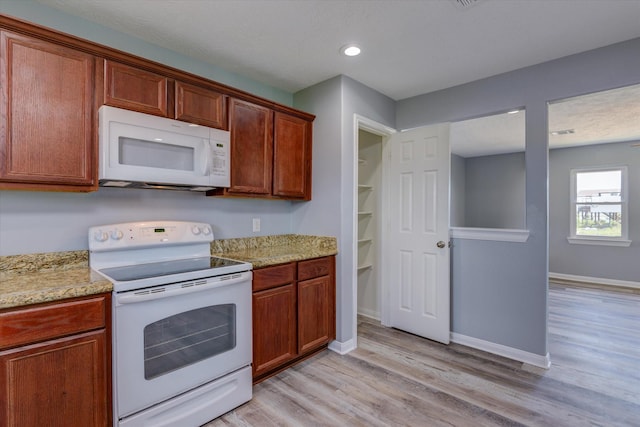 kitchen with baseboards, light stone countertops, recessed lighting, light wood-style floors, and white appliances