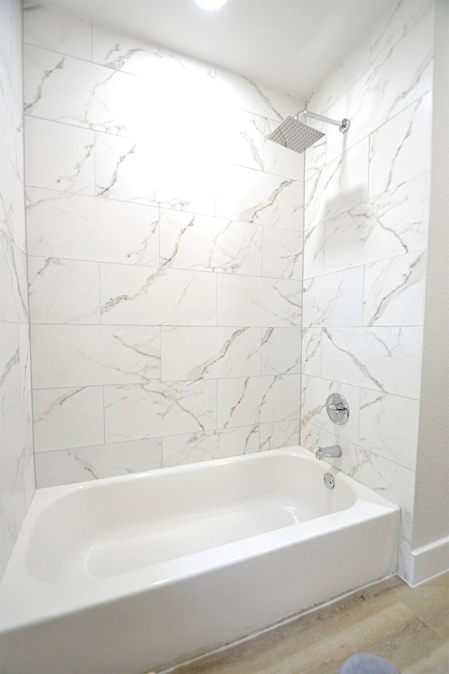 bathroom featuring hardwood / wood-style flooring and tiled shower / bath combo