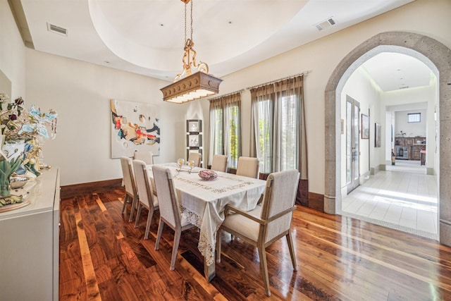 dining space featuring dark hardwood / wood-style flooring and a raised ceiling