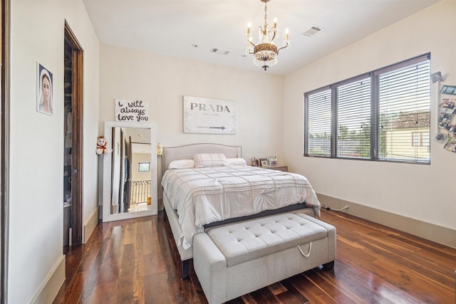 bedroom with a chandelier and dark hardwood / wood-style flooring