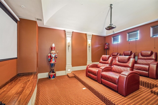 cinema with lofted ceiling, wood-type flooring, and decorative columns