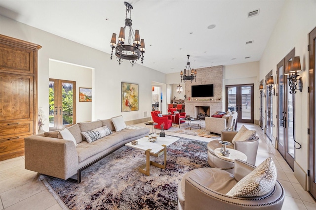 tiled living room with plenty of natural light, an inviting chandelier, and french doors