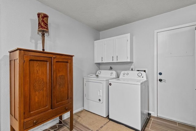 laundry room with washer and dryer, cabinets, a textured ceiling, and light wood-type flooring