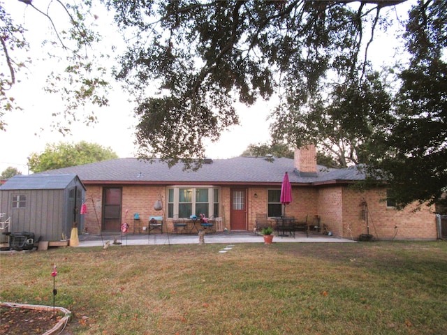 view of front facade with a storage shed, a patio, and a front yard