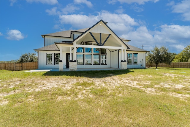 rear view of house featuring a yard and a patio