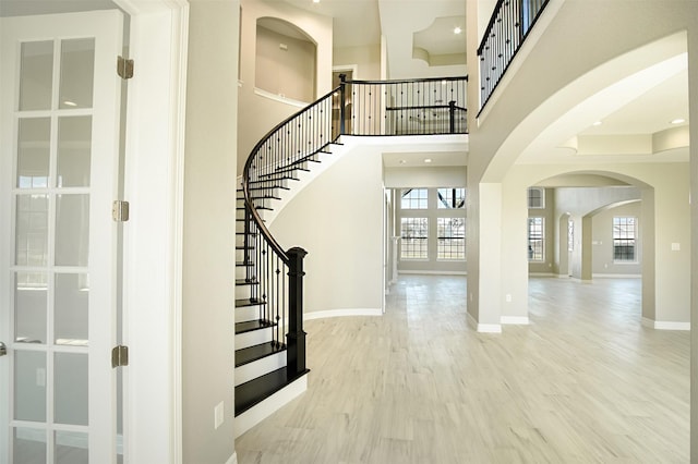 foyer featuring light hardwood / wood-style flooring and a towering ceiling