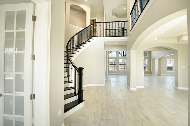 1714 Mackey Dr, Dickinson, TX 77539 - foyer entrance featuring wood finished floors, baseboards, stairway, arched walkways, and a towering ceiling
