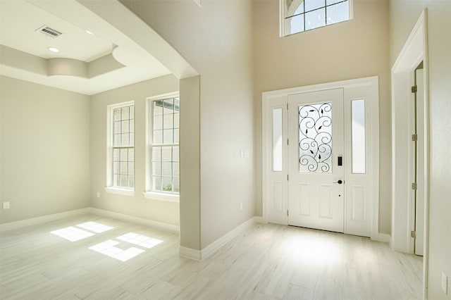 1714 Mackey Dr, Dickinson, TX 77539 - entrance foyer featuring light wood finished floors, baseboards, a towering ceiling, and a tray ceiling