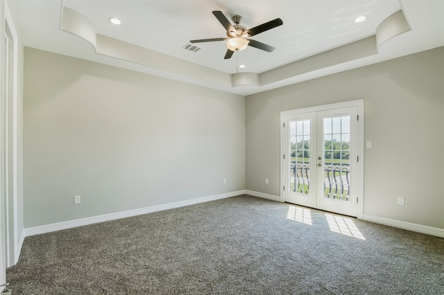 unfurnished room featuring carpet, french doors, and a raised ceiling