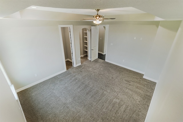 interior space with a walk in closet, ceiling fan, a closet, and carpet