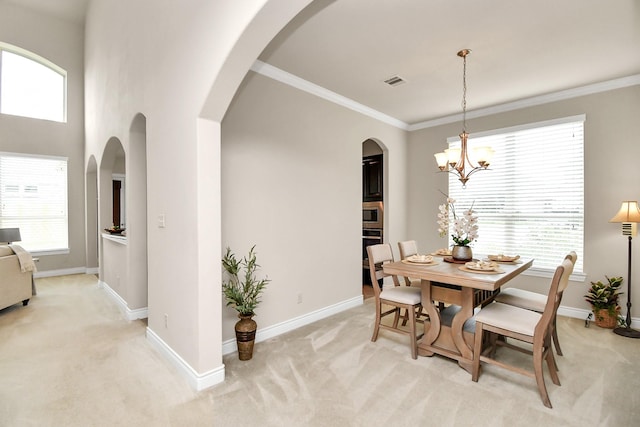 carpeted dining area featuring an inviting chandelier and crown molding