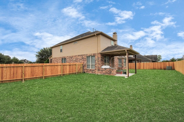 rear view of house with a patio and a lawn