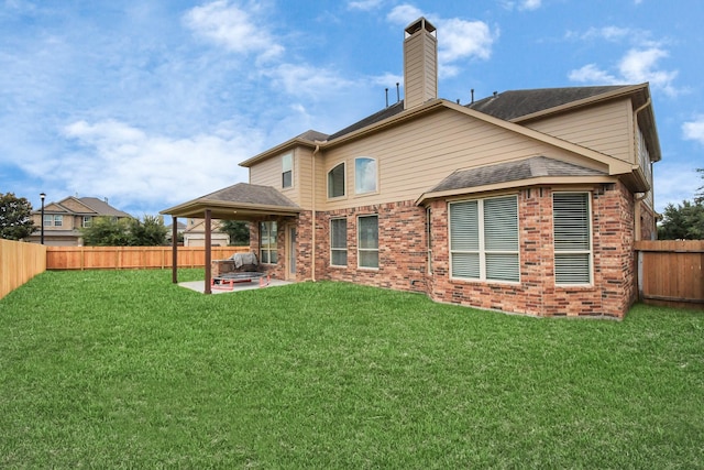 back of property featuring a lawn and a patio area