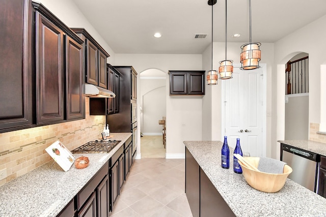 kitchen featuring light stone countertops, tasteful backsplash, decorative light fixtures, dark brown cabinets, and stainless steel appliances